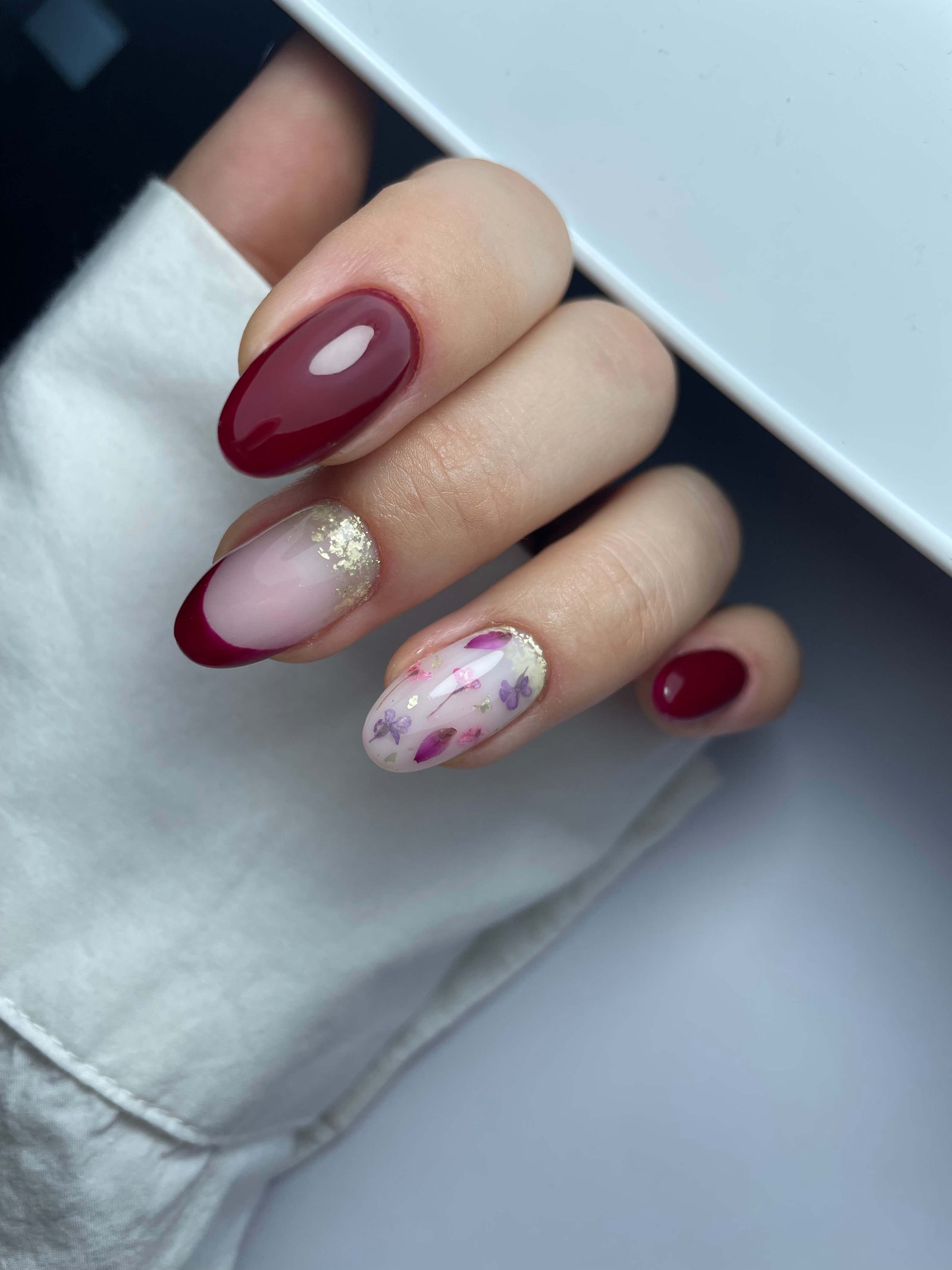 Mix manucure bordeaux french et aquarelle florale feuille d'or ongles ovales