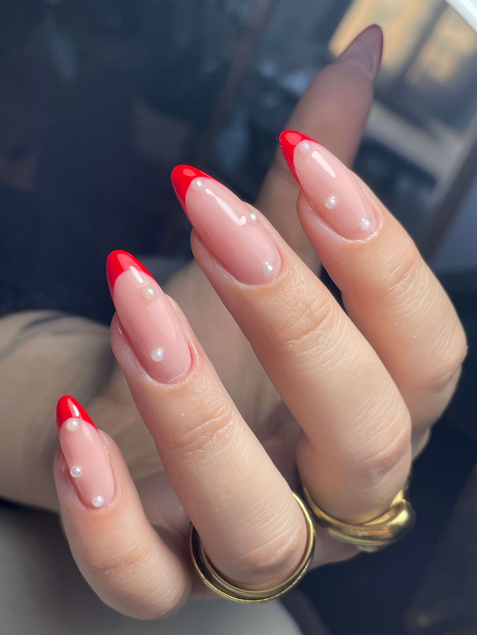 French manucure rouge avec perles blanches décoratives sur ongles amande