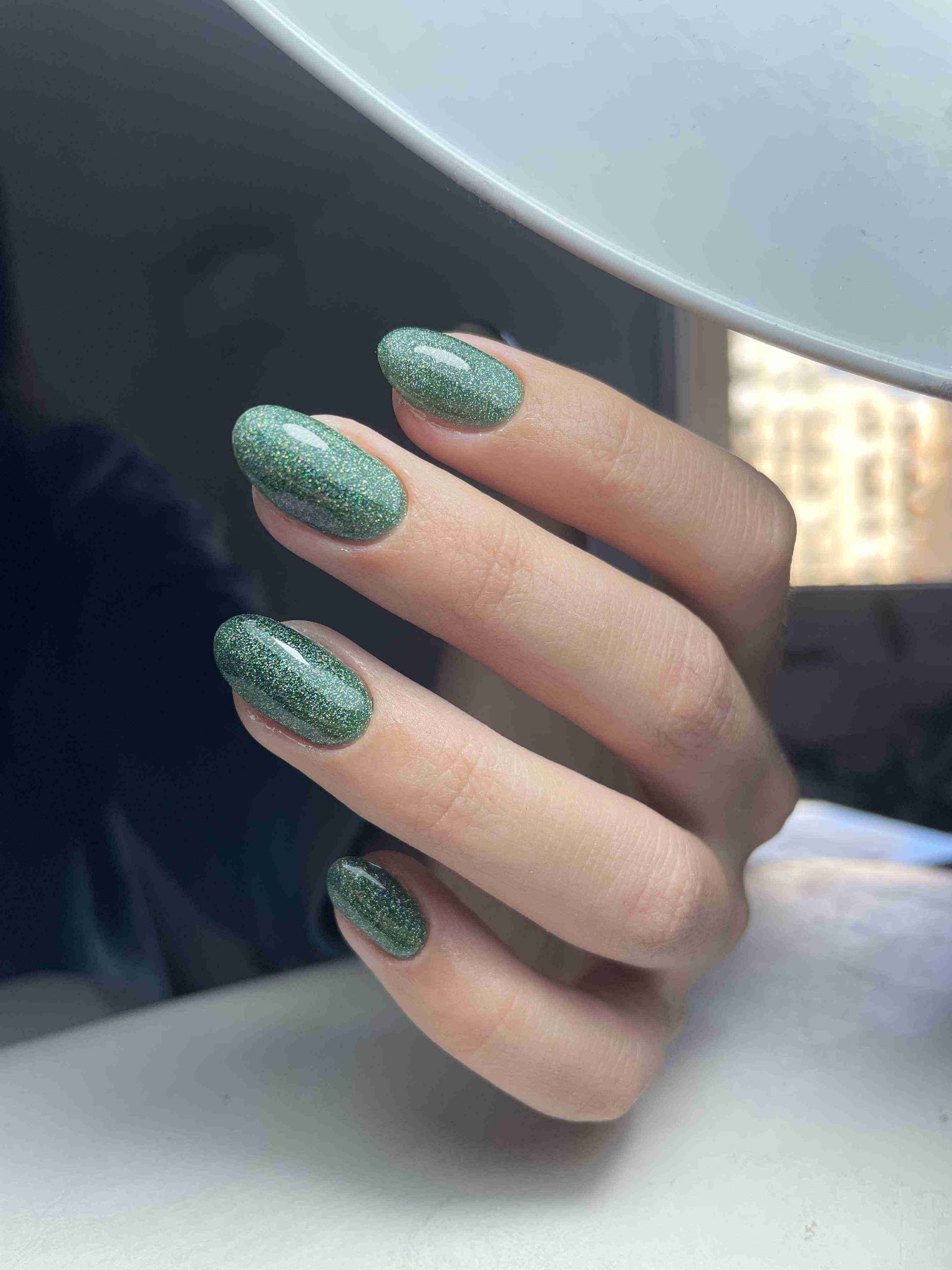 Vernis vert sapin avec paillettes dorées sur ongles ovales