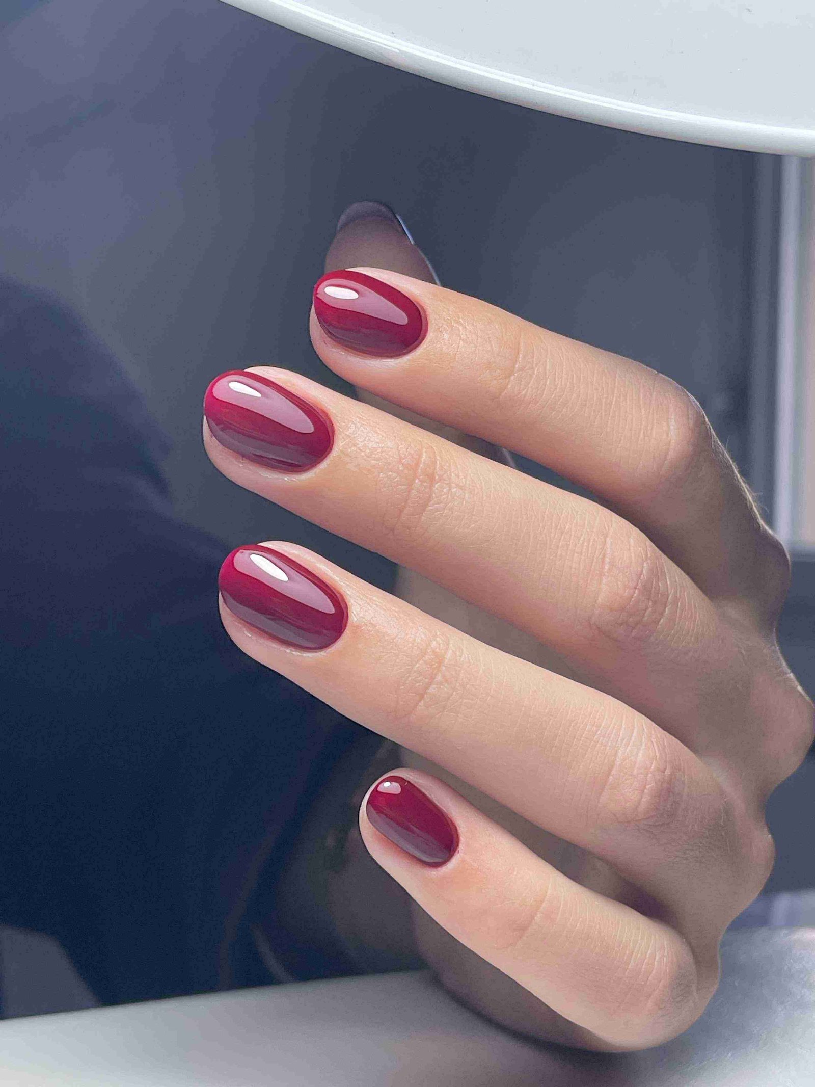 Vernis rouge cerise brillant glossy sur ongles ovales courts